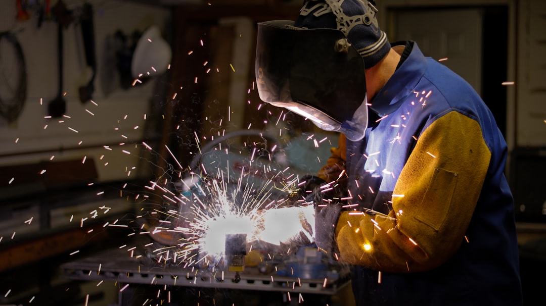 a-man-wearing-a-blue-protective-gear-working-on-a-machine-e15bqufhzjs